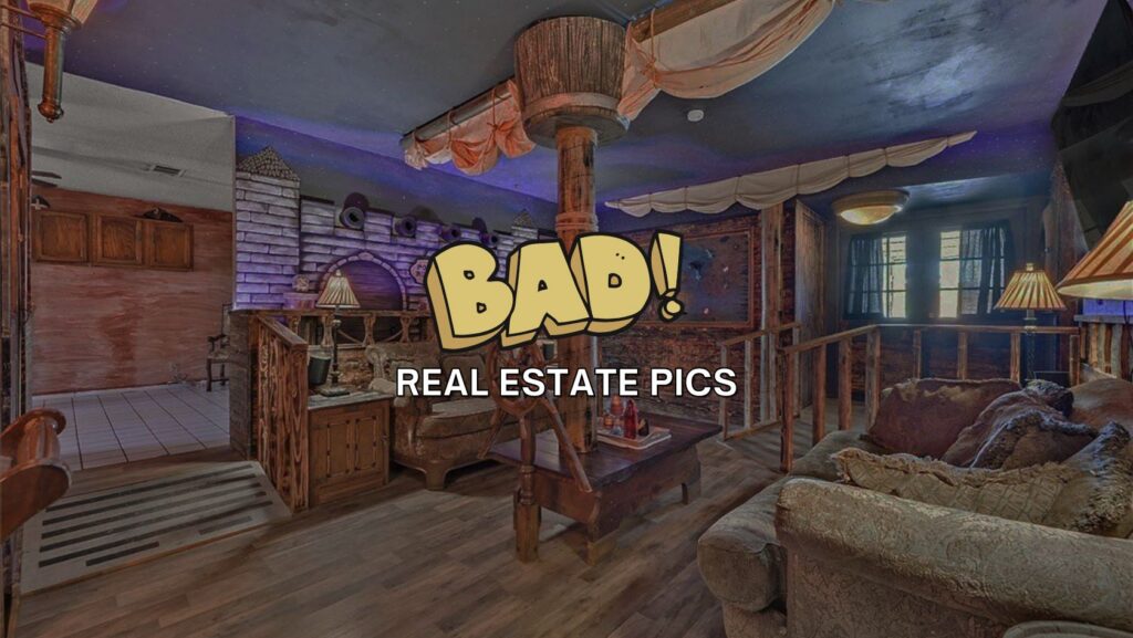 Rustic living room with wooden furniture and ship-themed ceiling; large couch and warm lamps, overlaid with bold 'BAD! REAL ESTATE PICS' text.