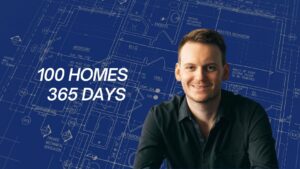 Smiling man in a dark shirt sits against a blue architectural blueprint backdrop with the text '100 HOMES 365 DAYS'.