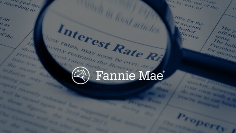 Close-up of a magnifying glass over a newspaper with an 'Interest Rate' headline and the Fannie Mae logo watermark.