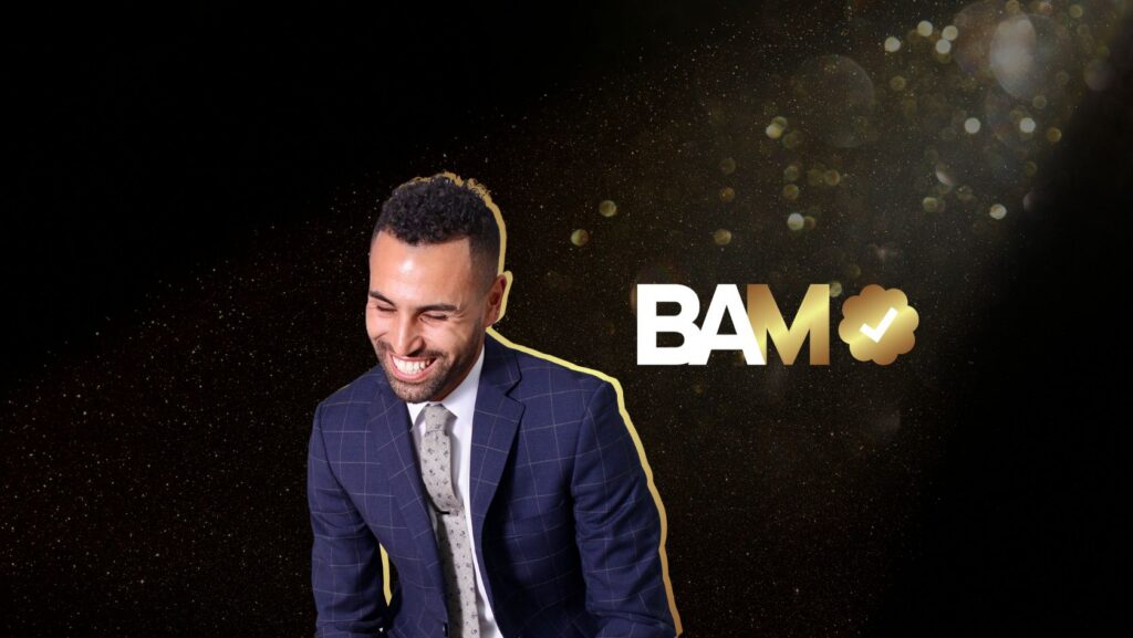 Smiling man in a blue plaid suit outlined in gold, beside bold 'BAM' with a gold clover and check mark on a starry black background.