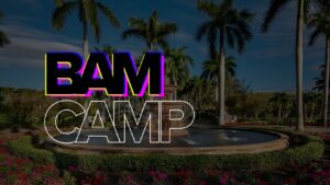 Promotional banner for BAM CAMP with large outlined letters over a fountain and palm trees in a tropical park setting.
