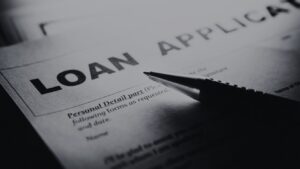 Close-up of a loan application form with the bold title 'LOAN APPLICATION' and a pen resting on it, ready to fill in details.