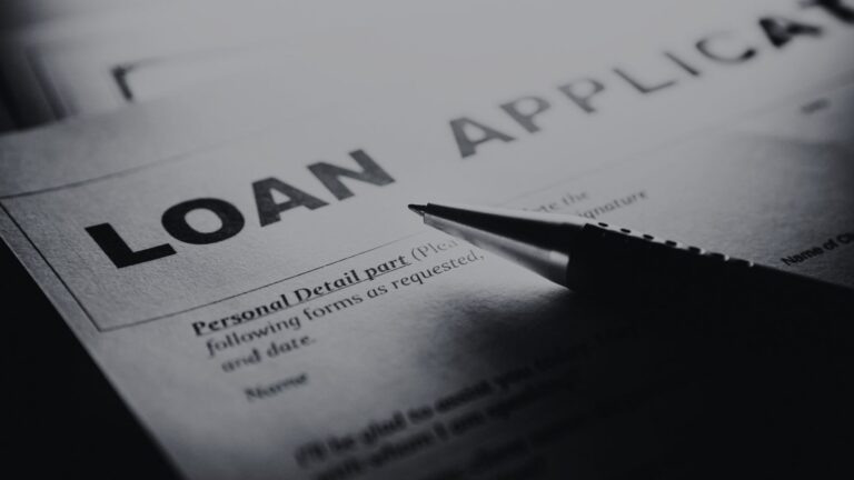 Close-up of a loan application form with the bold title 'LOAN APPLICATION' and a pen resting on it, ready to fill in details.