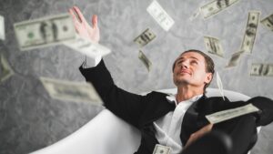 Man in a suit reclining in a white bathtub while dollar bills rain around him, conveying wealth and extravagance.