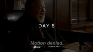 Dimly lit man with white beard sits at a desk; overlaid text reads 'DAY 8' with 'Motion denied.' and sponsor logos at the bottom.