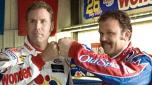 Two race car drivers in bright sponsor suits fist-bumping in a garage.