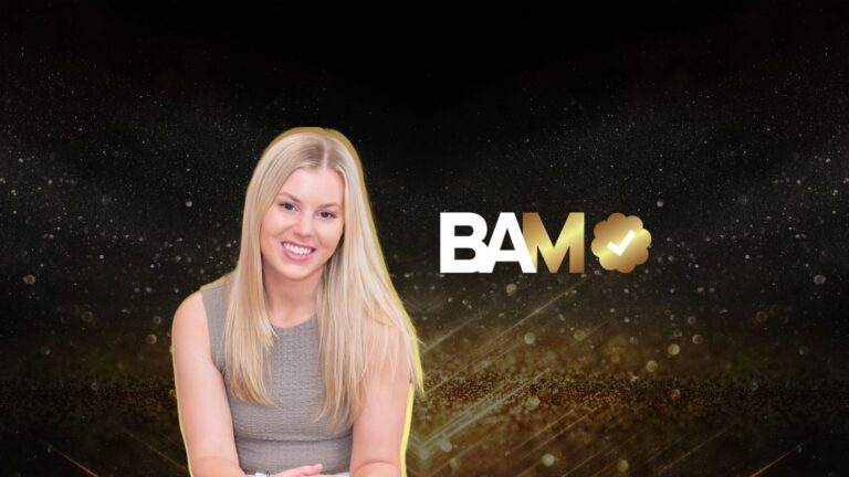 Smiling blonde woman in a beige sleeveless top posed against a glittery black and gold background with a BAM logo nearby.