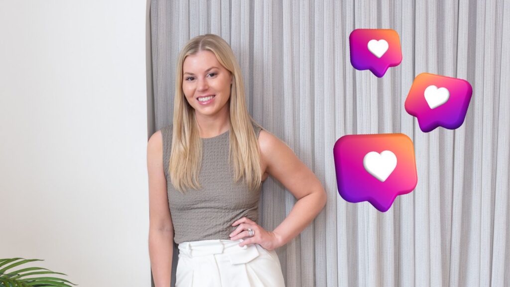 Portrait of a smiling blonde woman in a gray sleeveless top and white pants, standing by a curtain, with three floating like icons nearby to convey social media engagement.