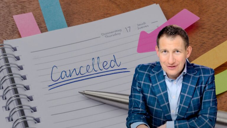 Notebook page shows 'Cancelled' written in blue with a silver pen nearby; man in a blue plaid blazer sits in the foreground.