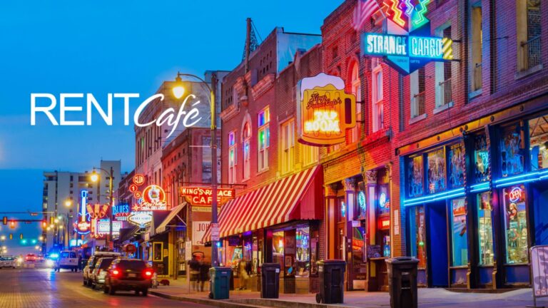 Lively neon-lit city street at dusk with colorful storefronts and signage, plus a RentCafe branding overlay on the left.