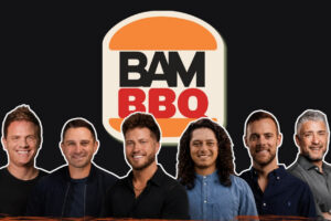 Six men stand side by side in front of a Bam BBQ logo on a dark background, smiling at the camera.