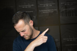 Man in a navy shirt looks down and points to the right, drawing attention off-screen against a dark background.