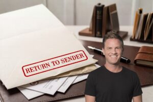 Envelope stamped 'Return to Sender' on a desk with papers, a pen, and a smiling man in a black t-shirt in the foreground.