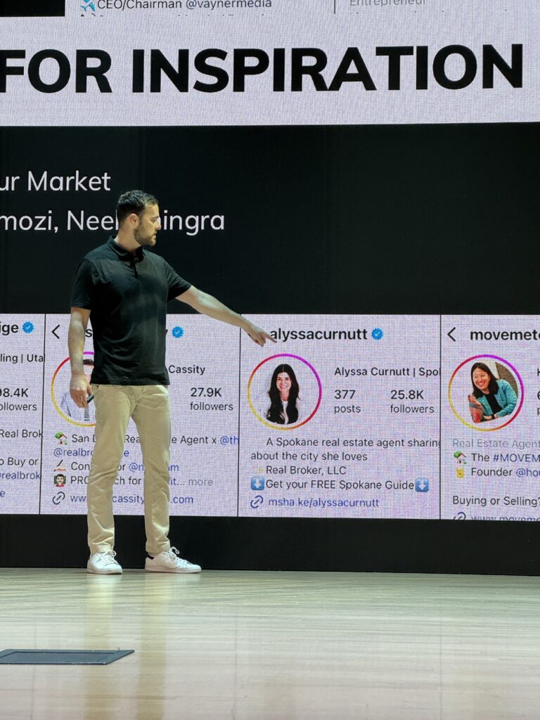 IMG_6262 - BAM Speaker in black polo and khaki pants points to a large screen showing social-media-style profile cards and the banner text 'FOR INSPIRATION' behind him.